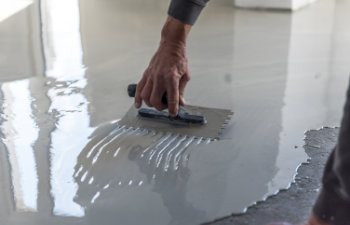 construction workers are painting the floor using the method self leveling epoxy